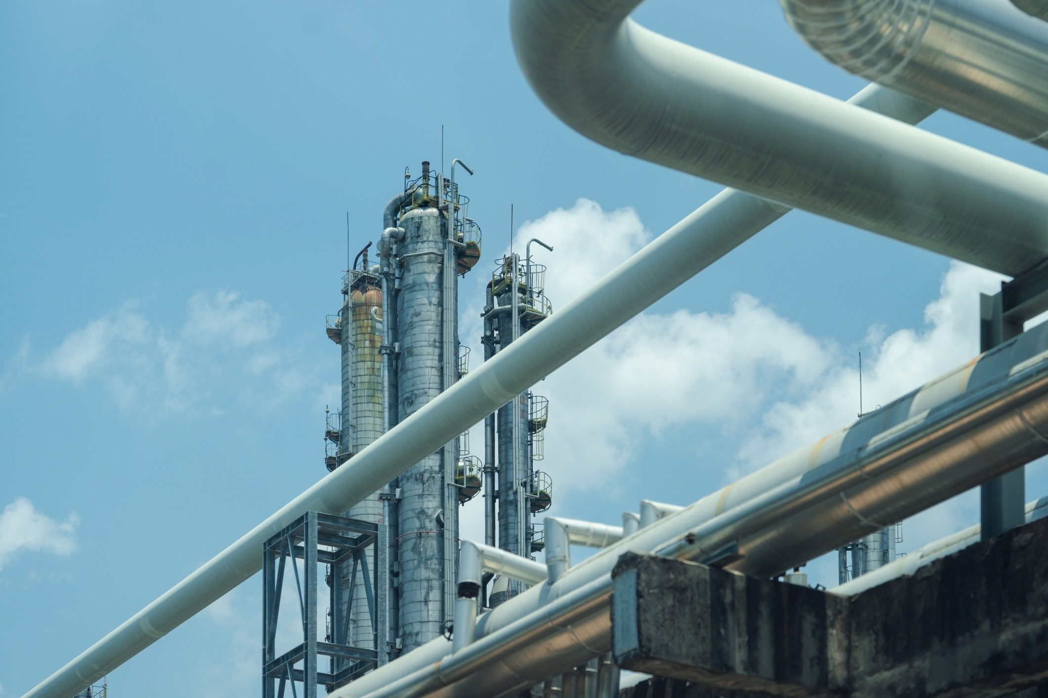 Oil and gas refinery plant form industry petroleum zone,Refinery equipment pipeline steel and oil storage tank. oil refinery and petrochemical industrial plant with pipelines under a clear blue sky.