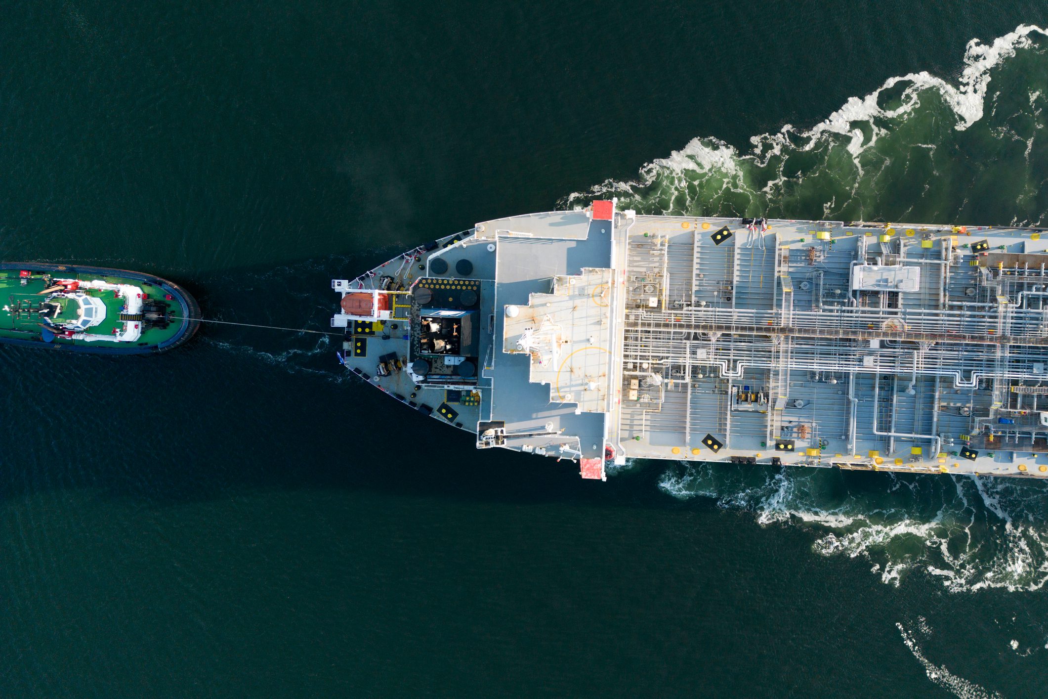 Aerial view of a large oil tanker and assisting tug boats in the port of Rotterdam
