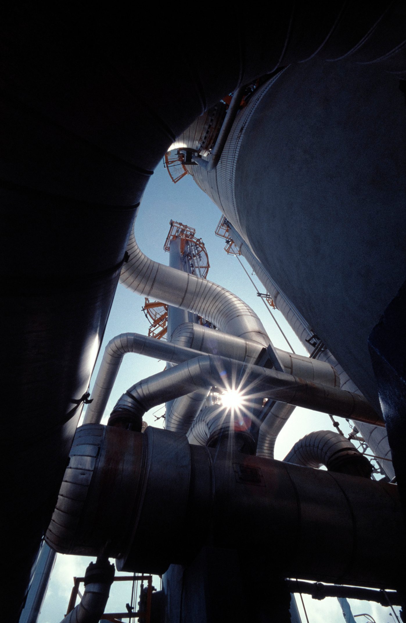 flares from the sun through the chimneys of refinery.see more relative images